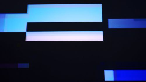 Low angle view of illuminated lights against blue sky