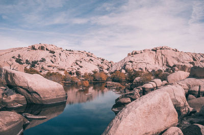 Scenic view of lake by mountain against sky