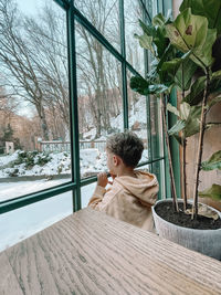 Side view of young woman sitting on railing