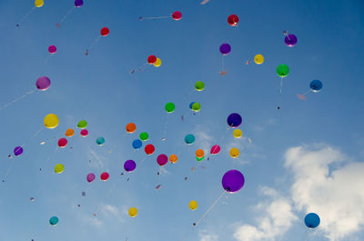 Low angle view of balloons flying against sky