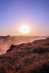 Scenic view of landscape against clear sky during sunset