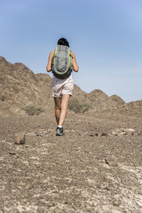Woman trekking in a wadi, dry mountains of  the middle east, arabian peninsula