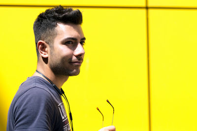 Man looking away by yellow wall