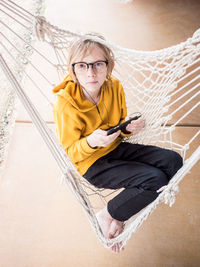 Portrait of tween in hammock listening to music with earbuds