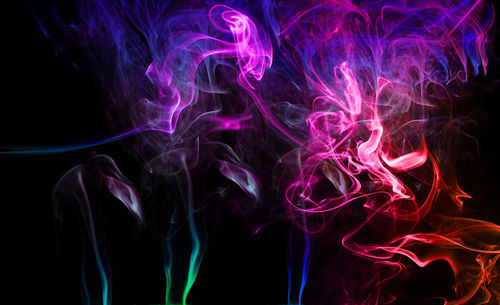 Close-up of colorful smoke against black background