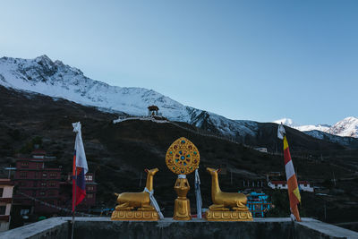 Rear view of woman standing on mountain against clear blue sky