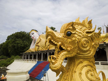 Statue against temple and building against sky