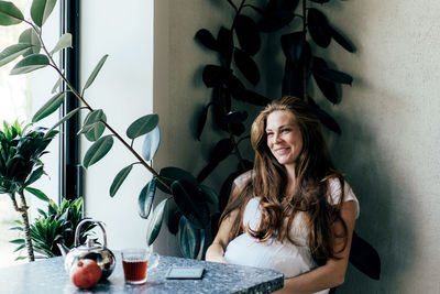 Smiling pregnant woman sitting at caf�