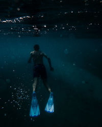 Rear view of man swimming in sea