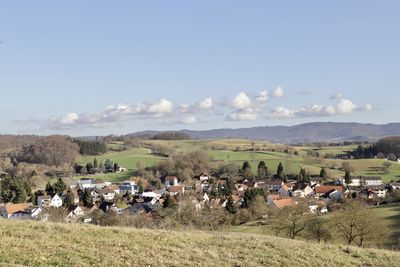 Panoramic view of field and buildings against sky