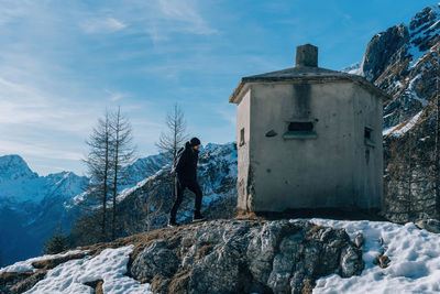 Man walking toward world war 1 bunker on top of vrsic mountain pass in julian alps in slovenia