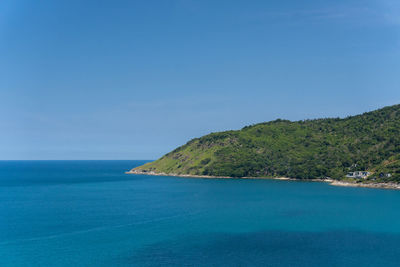 Seascape part of the beautiful island full of forest trees in deep blue ocean clear summer sky