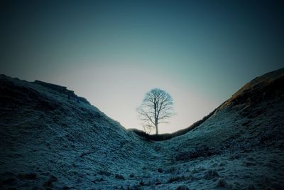 Scenic view of snow covered land against clear blue sky