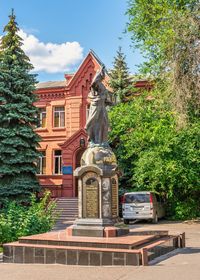 Statue by building against sky