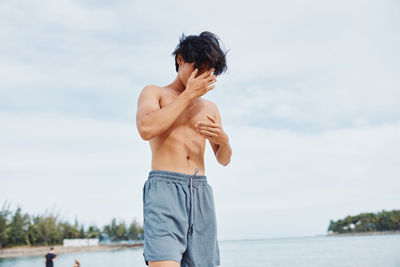 Side view of woman standing against lake