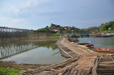 Bridge over river in city against sky