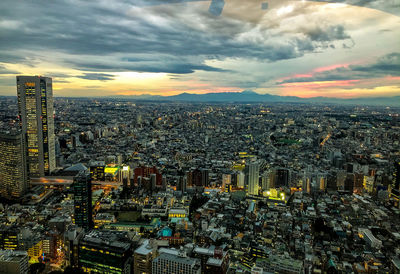 High angle view of illuminated cityscape against sky during sunset
