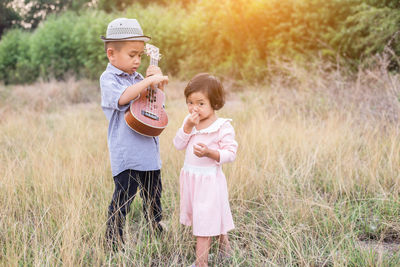 Siblings standing on field