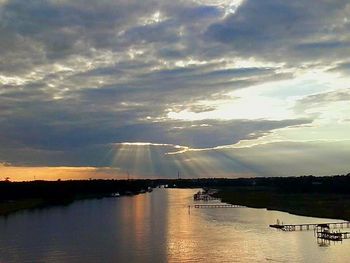 Scenic view of river against cloudy sky