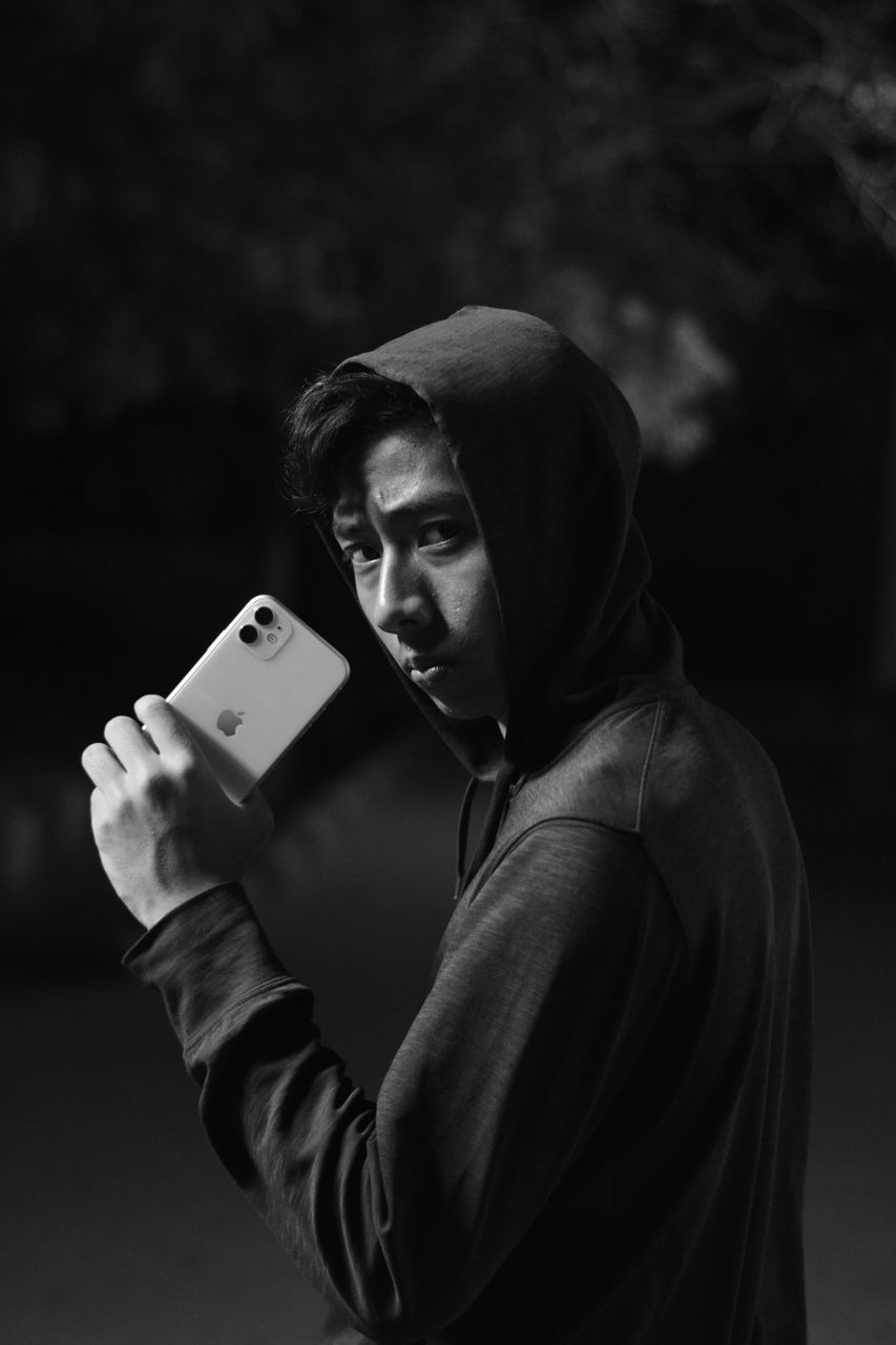 PORTRAIT OF YOUNG MAN USING SMART PHONE