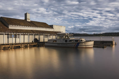 Houses by river against sky