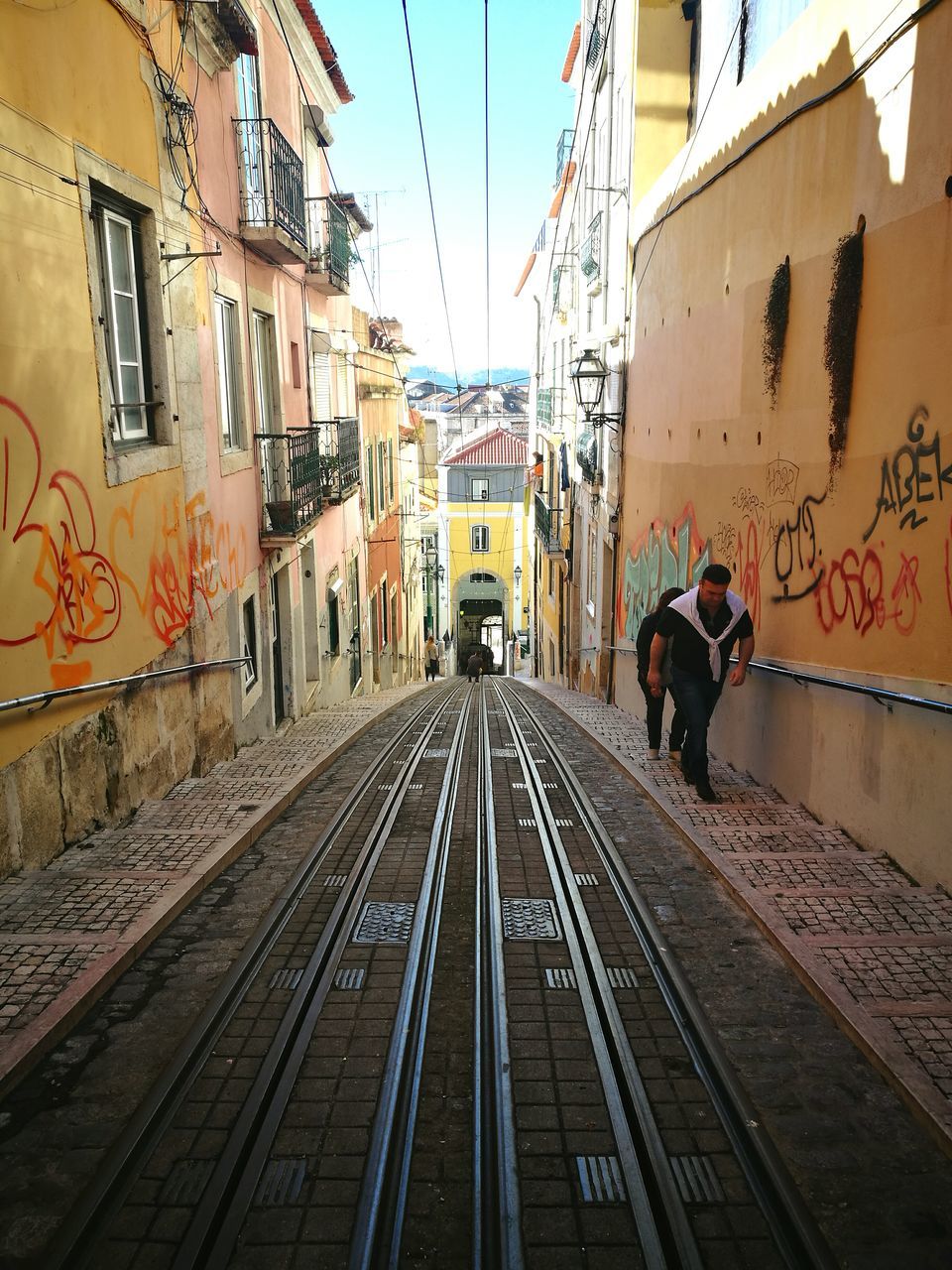 PEOPLE ON RAILROAD TRACKS IN CITY