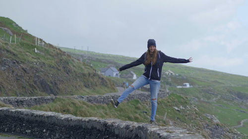 Full length of woman standing on mountain road