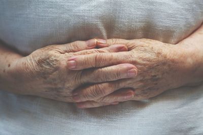 Midsection of woman with hands clasped