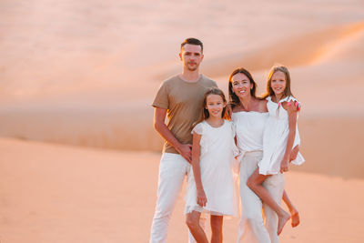 Portrait of family standing on sand dunes at desert