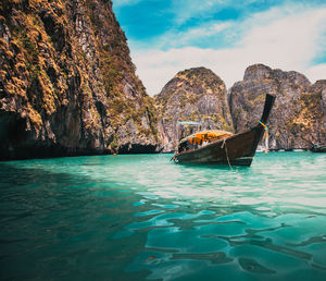 Boat in sea against mountain