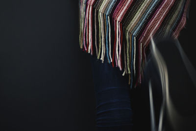 Midsection of person wearing poncho while running against black background