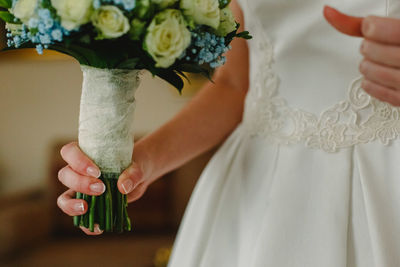 Midsection of woman holding flower bouquet