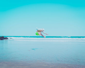 Man surfing on beach against sky