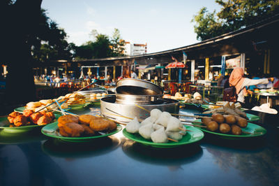 Various food served in plates arranged on table at market stall