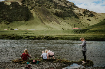 PEOPLE ON LAKE BY MOUNTAIN