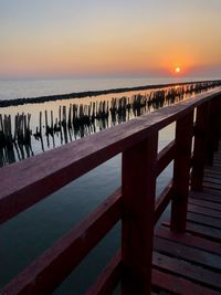 Pier over sea against sky during sunset