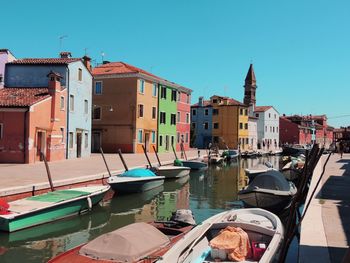 Boats moored in water against clear sky