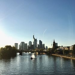 River by buildings in city against sky