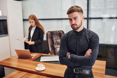 Portrait of businessman using mobile phone in office