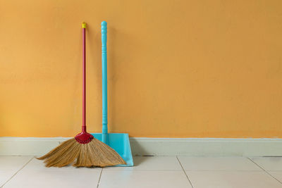 Close-up of parasol on floor against wall