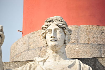 Low angle view of statue against wall against sky