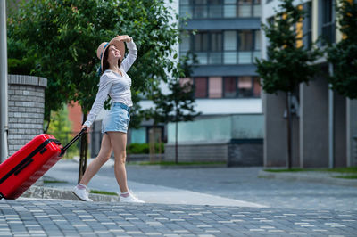 Full length of woman on footpath in city