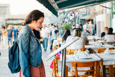 Young tourist woman looking the menu of a restaurant  in the seaport of san sebastian.spain