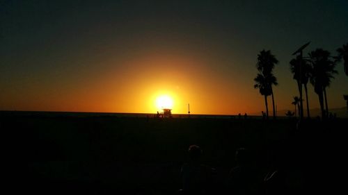 Silhouette palm trees against sky during sunset