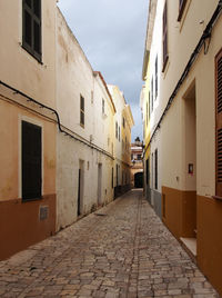 Footpath amidst buildings against sky