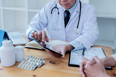 Midsection of man using smart phone on table