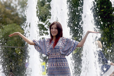 Full length of happy woman standing in water