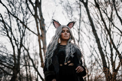 Young woman standing against tree during autumn