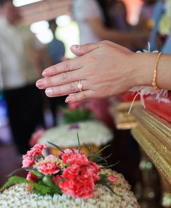 Close-up of hand holding red flowers