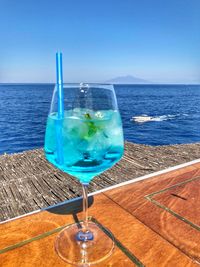 Blue water on table by sea against sky